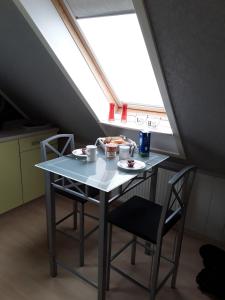 - une table et des chaises dans une chambre avec fenêtre dans l'établissement Ferienwohnung Nordlicht, à Nortorf