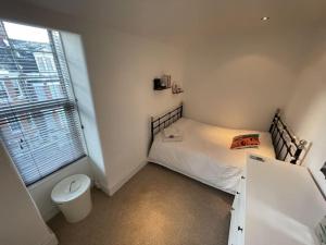 a small bedroom with a bed and a toilet at Spacious two bedroom flat in prestigious Highgate. in London