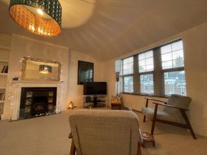 a living room with a fireplace and a mirror at Spacious two bedroom flat in prestigious Highgate. in London