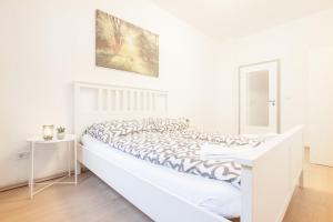 a white bedroom with a large white bed with a white bed frame at TM Studio in Dortmund