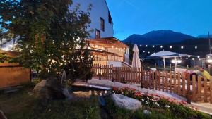 a building with a fence and flowers in front of it at Hotel Angelo in Comano Terme