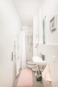 La salle de bains blanche est pourvue de toilettes et d'un lavabo. dans l'établissement TM Studio, à Dortmund