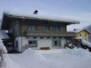 ein Haus mit einem Stapel Schnee davor in der Unterkunft Ferienwohnung Enn in Neukirchen am Großvenediger