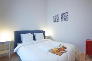 ein weißes Bett mit einem Tablett mit Essen drauf. in der Unterkunft South Cosy Residence in Brüssel