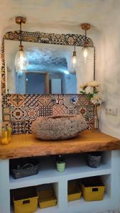 a mirror on a wall above a wooden table with a sink at Cueva OTTO Privada in Baza