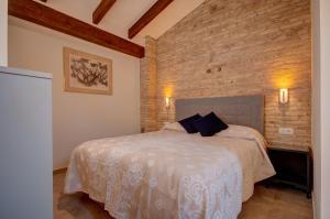 バレンシアにあるBeds & Breaks Verdi 2のレンガの壁、ベッド付きのベッドルーム1室