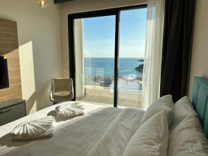 um quarto com uma cama e uma grande janela em Boreti Residence em Budva