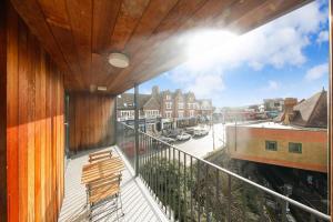 einen Balkon mit einem Stuhl und Stadtblick in der Unterkunft 3bed Penthouse 10min to Wimbledon tennis courts in London