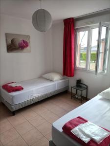 a bedroom with two beds and a window at Domaine des Garrigues in Grospierres