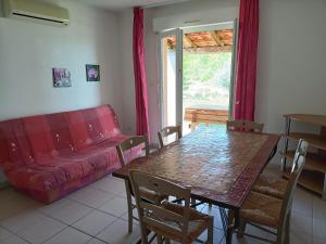 a living room with a table and a red couch at Domaine des Garrigues in Grospierres