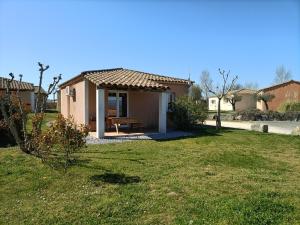 a small house with a picnic table in a yard at Domaine des Garrigues in Grospierres