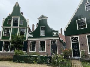 une maison avec un toit vert et une clôture dans l'établissement CS 61 - Vakantiepark Callassande, à Callantsoog