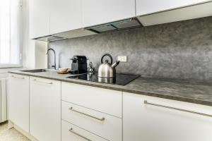 a kitchen with white cabinets and a tea kettle on the counter at BePlace Apartments in Porta Garibaldi in Milan