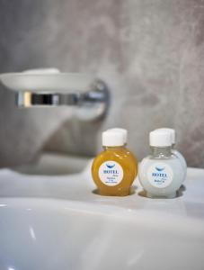 two bottles of honey sitting on a bathroom sink at Garnet Hotel Tashkent in Tashkent
