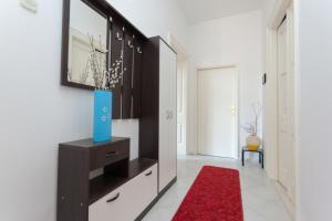 a living room with a red rug and a mirror at Apartment Red Coral in Dubrovnik