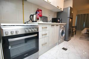 Il comprend une cuisine équipée d'une cuisinière et d'un lave-linge. dans l'établissement Exceptional Furnished Studio, à Dubaï