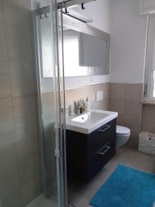 a bathroom with a sink and a glass shower at Condominio Schiusa in Grado