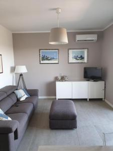 a living room with a couch and a tv at Condominio Schiusa in Grado