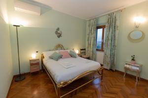 a bedroom with a bed with white sheets and pink pillows at DOLF - Villa Elisa - Intera Villa in Tolentino +15 photos