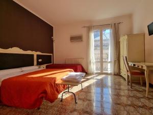a bedroom with two beds and a desk and a window at Piazza Politeama in Palermo