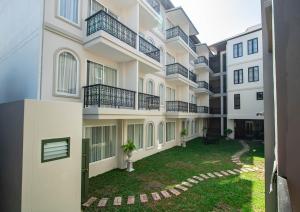an apartment building with balconies and a yard at Eurana Boutique Hotel in Chiang Mai