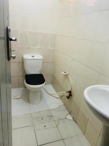 a dirty bathroom with a toilet and a sink at Mikocheni Home stay in Dar es Salaam