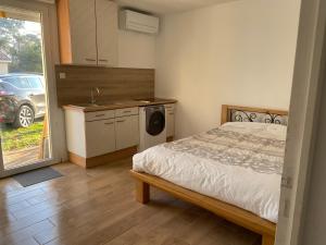 1 dormitorio con 1 cama, lavamanos y lavadora en Studio proche bordeaux, en Cadaujac