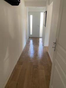 przedpokój z drewnianą podłogą i drzwiami w obiekcie Studio proche bordeaux w mieście Cadaujac