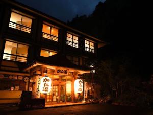 日光的住宿－奥鬼怒温泉酒店 加仁汤(Okukinu Onsen Hotel Kaniyu)，一座在晚上有 ⁇ 虹灯标志的建筑