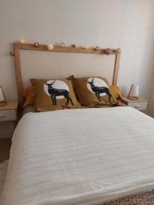 een bed met twee zwart-witte kussens erop bij L'Appartement Gabriel T2 in Bergerac