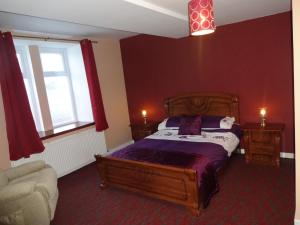 a bedroom with a bed and a chair and a window at St. Cyrus Village Inn in Saint Cyrus