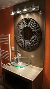a bathroom with a glass sink and a mirror at GITE LES GRANDES VIGNES, SUD Ardèche, indépendant et privatisé, piscine chauffée, climatisation, SPA, 11 chambres, 8 salles de bains in Sanilhac