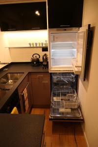 uma cozinha com um frigorífico vazio com a sua porta aberta em Ferienhaus Oberguet em Unterwasser