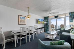 uma sala de estar com uma mesa e cadeiras e um sofá em Atlantica 11th Floor Gem! em Myrtle Beach