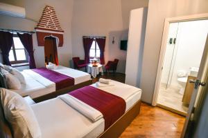 a hotel room with two beds and a bathroom at Taşhan Hotel in Edirne