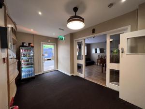 a room with a drink refrigerator and a dining room at The Commongate Hotels in London