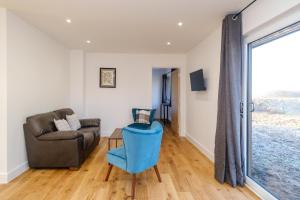 a living room with a couch and a chair at Three Tuns - Garden Suite 1 in Wickham Market