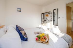 a tray of fruit on a white bed at Three Tuns - Garden Suite 1 in Wickham Market