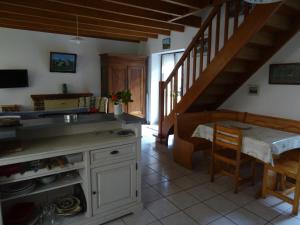eine Küche mit einer Theke, einem Tisch und einer Treppe in der Unterkunft Gîte au coeur de la Bretagne in Roudouallec