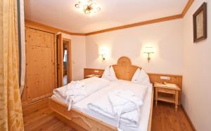 Un dormitorio con una cama con toallas blancas. en Erlebnisgut & Reiterhof Oberhabach, en Kirchdorf in Tirol