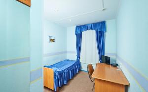 Habitación con escritorio y cama con ventana en Gornitsa Hotel, en Kirovsk