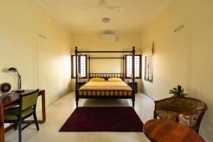 a bedroom with a bed and a desk and a chair at Luho 187 in Bangalore
