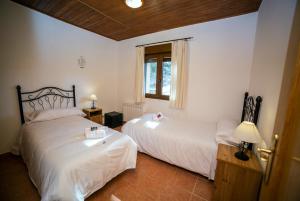 a bedroom with two beds and a window at Eras del Poeta in Casillas