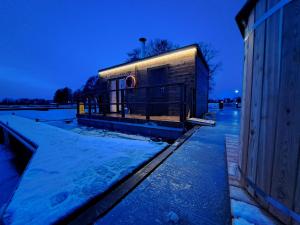 a building with snow on the ground next to a building at Pensjonat Sztynort in Sztynort