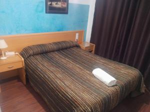 a hotel room with a bed with a white towel on it at Pensión Iglesias in Zaragoza