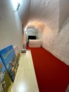 a room with a red and white hallway with a bed at Gîtes de Chauvet in Gap