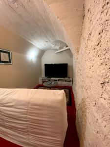 a bedroom with a white bed and a tv at Gîtes de Chauvet in Gap