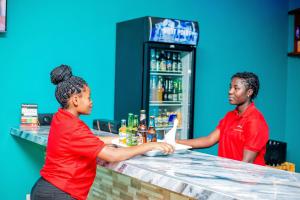 two people standing at a counter in a bar at Kiteme Comfort Lodge in Arusha