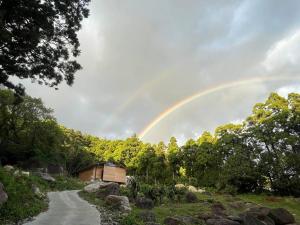 a rainbow in the sky over a dirt road at スナッパーロック 屋久島 in Yakushima