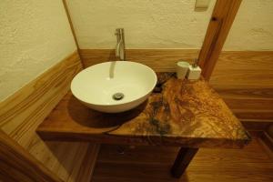 La salle de bains est pourvue d'un lavabo blanc sur une table en bois. dans l'établissement スナッパーロック 屋久島, à Yakushima